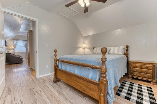 bedroom featuring ceiling fan, lofted ceiling, and light hardwood / wood-style flooring