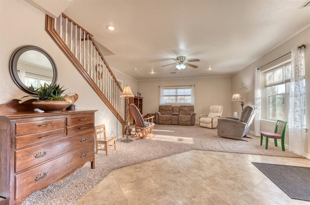 living room with light carpet, ceiling fan, and ornamental molding