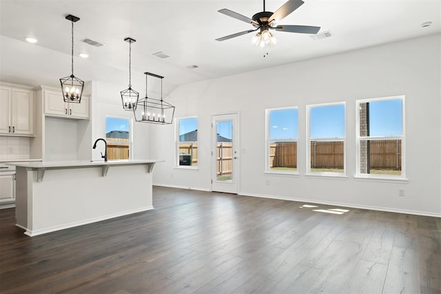 unfurnished living room featuring ceiling fan, sink, and dark hardwood / wood-style floors