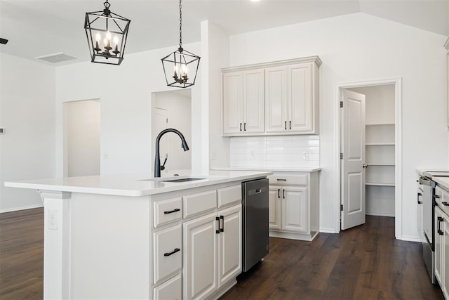 kitchen with dark wood-type flooring, a center island with sink, sink, stainless steel dishwasher, and white cabinetry