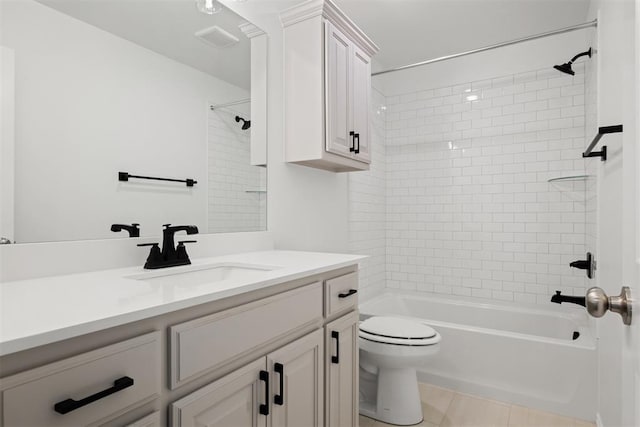 full bathroom featuring toilet, vanity, tile patterned floors, and tiled shower / bath combo