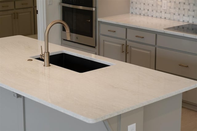 kitchen featuring gray cabinets, sink, stainless steel oven, and black electric stovetop