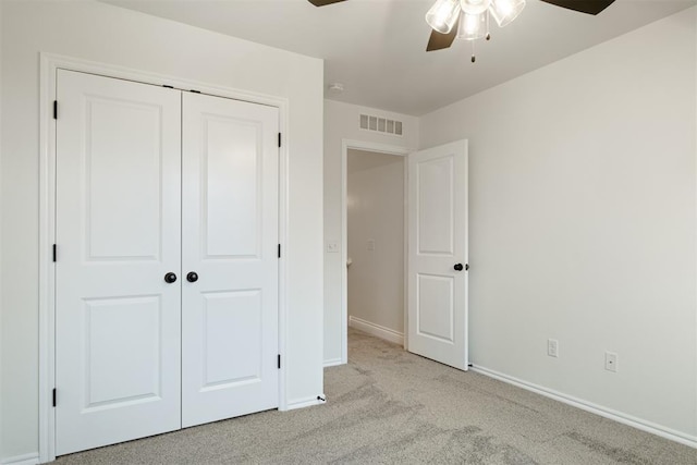 unfurnished bedroom with ceiling fan, a closet, and light colored carpet