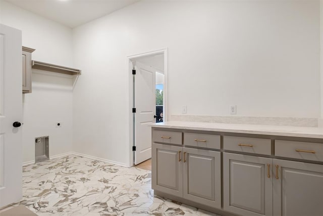 laundry room with electric dryer hookup and cabinets