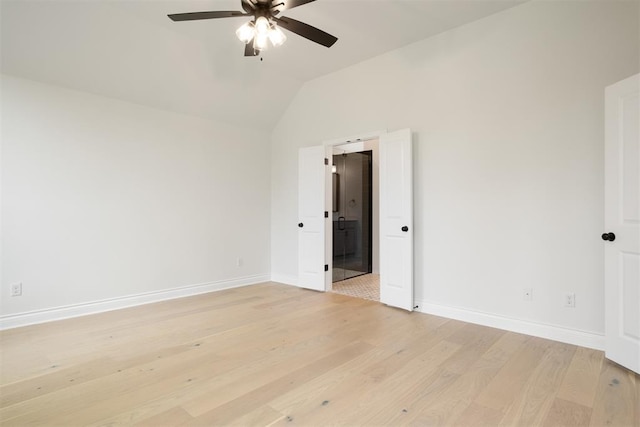 spare room featuring light wood-type flooring, vaulted ceiling, and ceiling fan