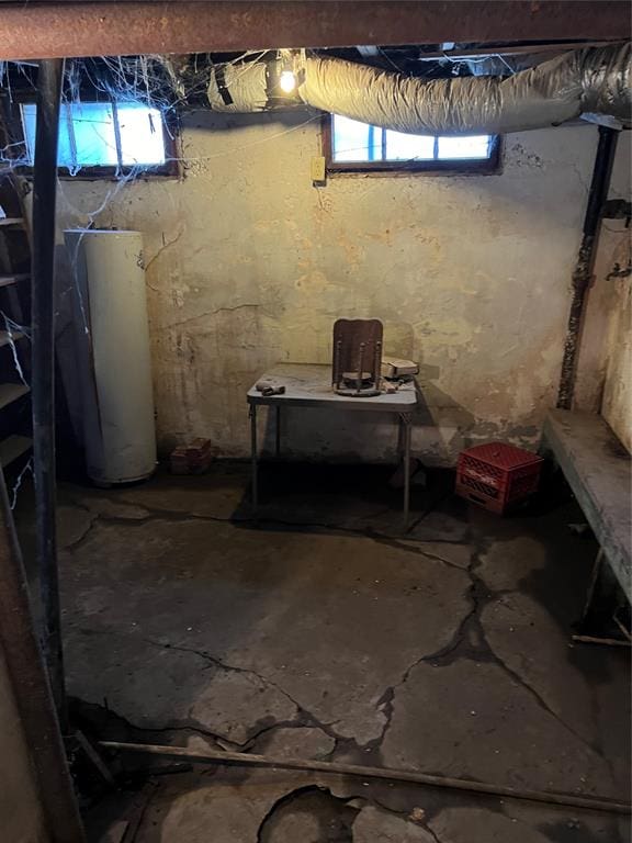 basement featuring a healthy amount of sunlight and water heater