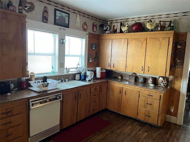 kitchen featuring dishwashing machine, dark hardwood / wood-style flooring, and sink