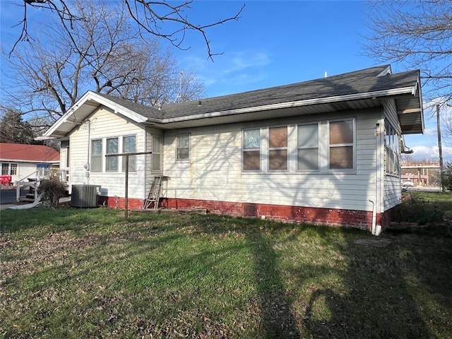 view of side of home featuring a yard and central air condition unit