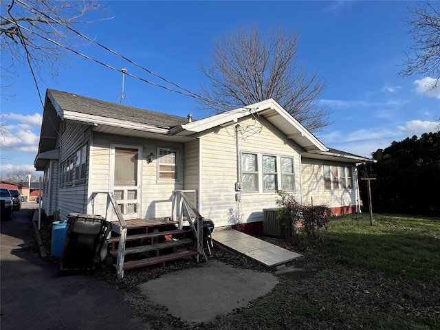 view of front of property with cooling unit and a front lawn