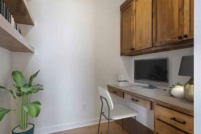 office space with light hardwood / wood-style flooring and built in desk