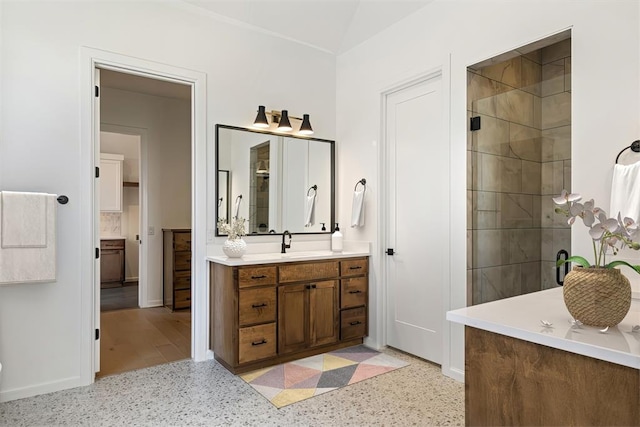 bathroom featuring a tile shower and vanity