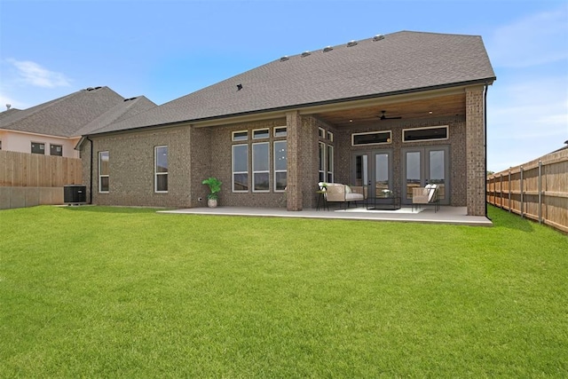 back of property with ceiling fan, a yard, cooling unit, and a patio