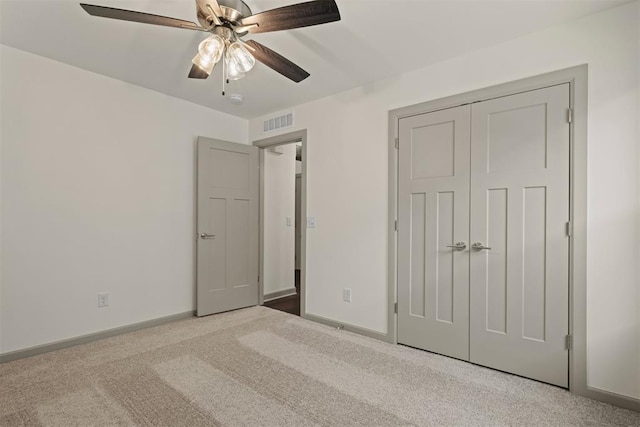 unfurnished bedroom with ceiling fan, a closet, and light colored carpet