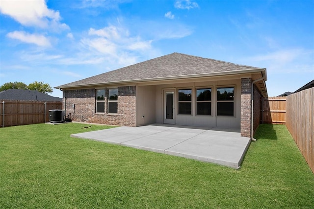 back of property with a lawn, a patio area, and central AC