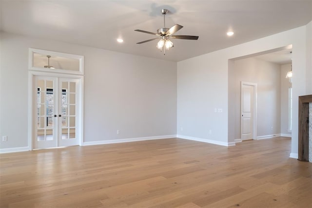 empty room with french doors, light hardwood / wood-style flooring, and ceiling fan