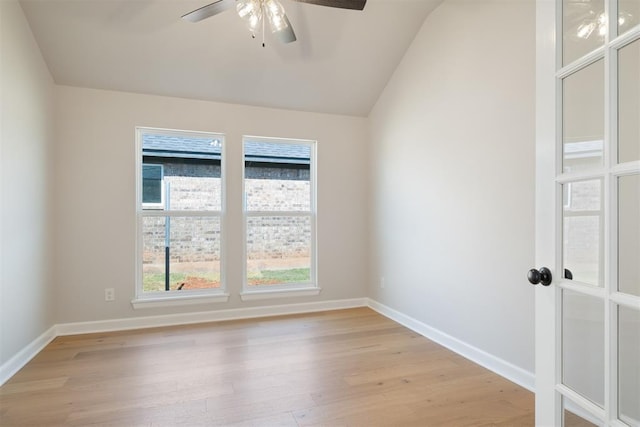 spare room featuring ceiling fan, lofted ceiling, and light wood-type flooring