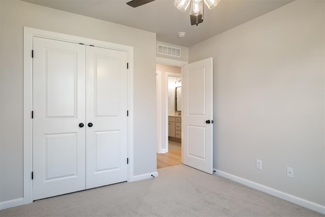 unfurnished bedroom with ceiling fan, a closet, and light colored carpet