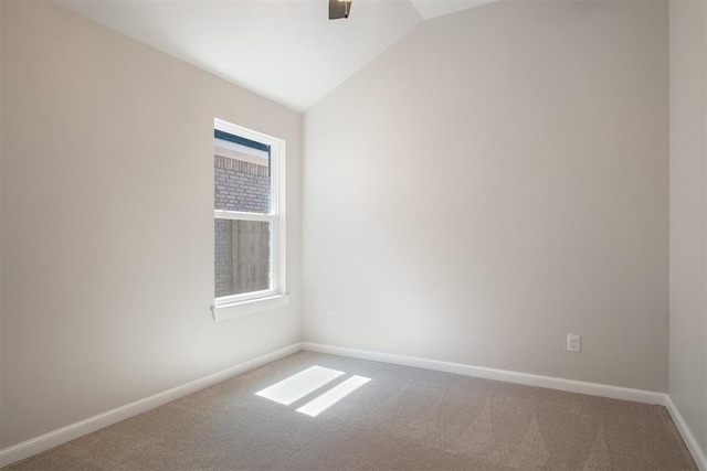 carpeted empty room with lofted ceiling