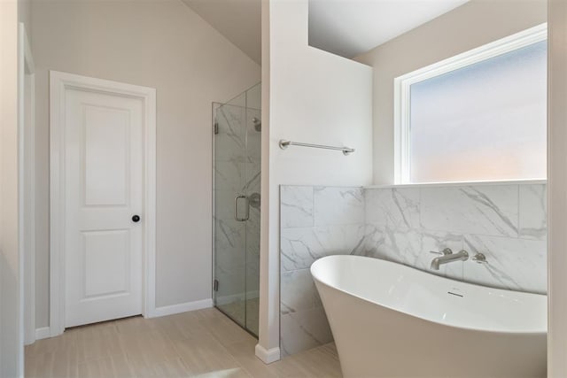 bathroom with separate shower and tub, tile walls, and vaulted ceiling