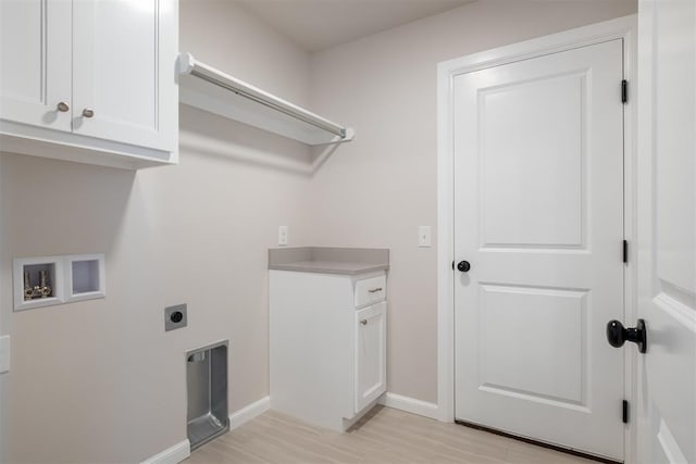 washroom with electric dryer hookup, cabinets, washer hookup, and light wood-type flooring