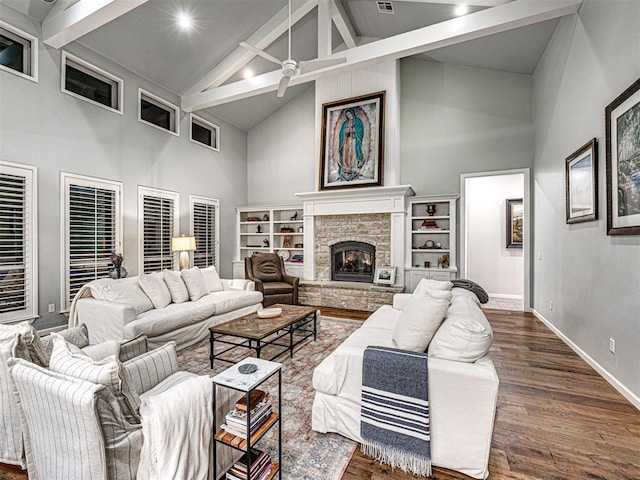 living room featuring dark wood-type flooring, high vaulted ceiling, ceiling fan, a fireplace, and beamed ceiling