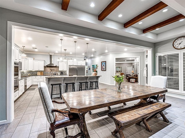 dining room with sink and beamed ceiling