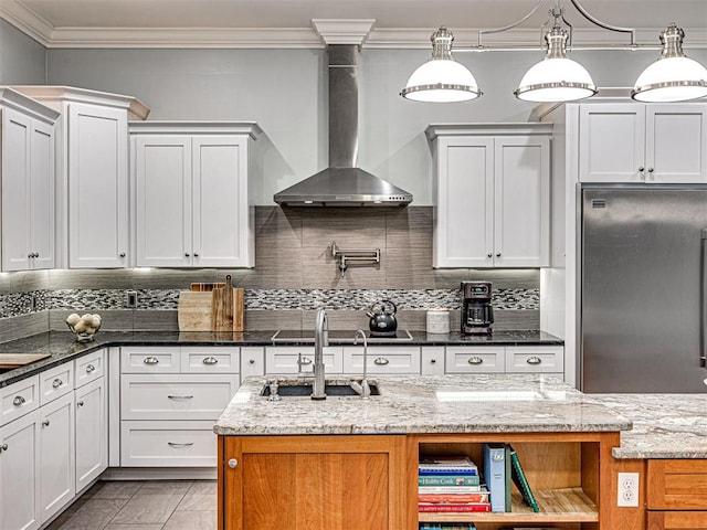 kitchen with dark stone countertops, white cabinets, wall chimney exhaust hood, and stainless steel appliances