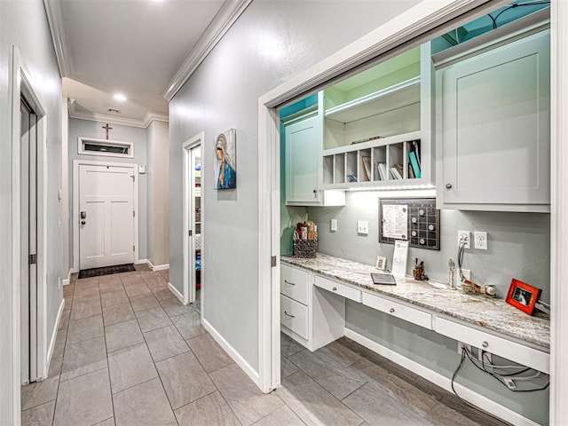 hallway featuring ornamental molding and light tile patterned floors