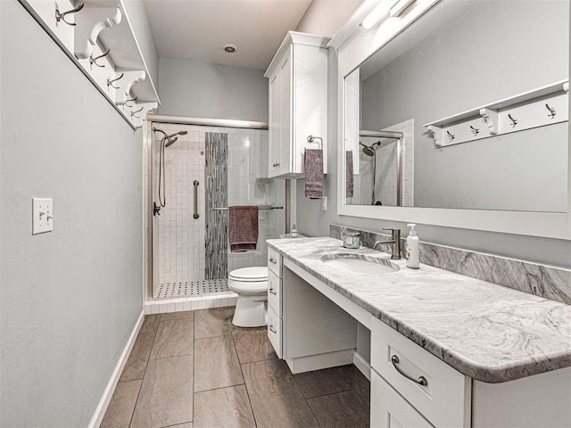 bathroom featuring tile patterned flooring, a shower with door, vanity, and toilet