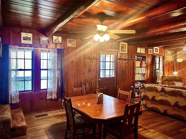 dining space featuring a healthy amount of sunlight, wood-type flooring, and wooden ceiling