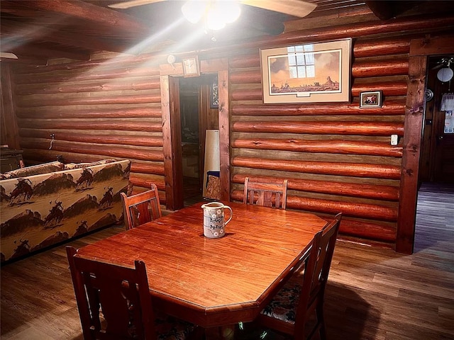 dining space with dark hardwood / wood-style floors and log walls