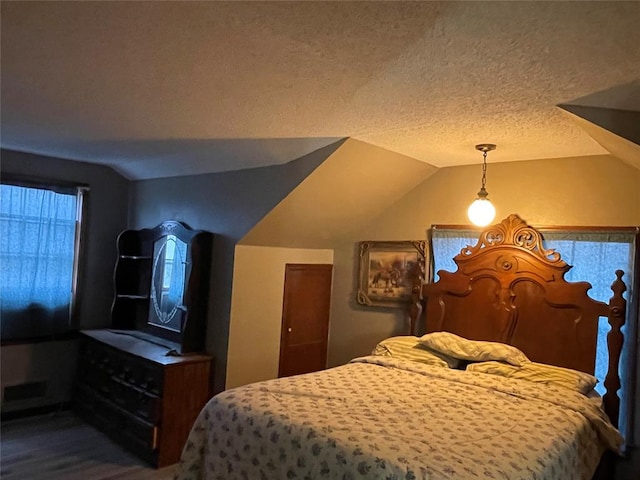 bedroom with a textured ceiling and vaulted ceiling