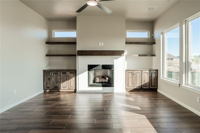 unfurnished living room with ceiling fan, dark hardwood / wood-style flooring, and a fireplace