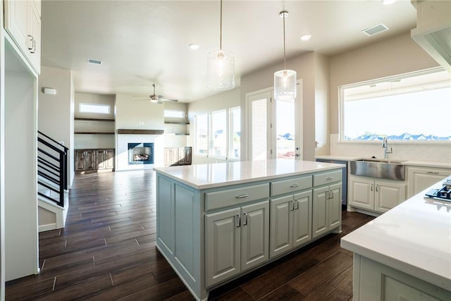 kitchen featuring white cabinets, a kitchen island, dark hardwood / wood-style flooring, and pendant lighting