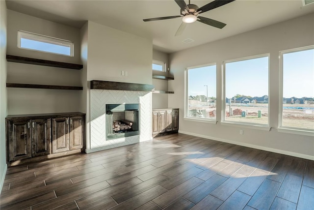 unfurnished living room featuring a fireplace, ceiling fan, and dark hardwood / wood-style flooring