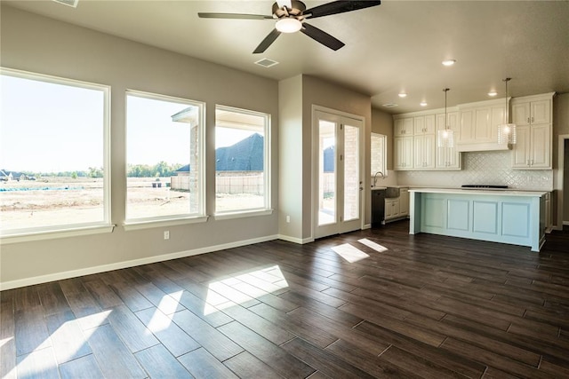 kitchen featuring ceiling fan, a center island, dark hardwood / wood-style floors, white cabinetry, and hanging light fixtures