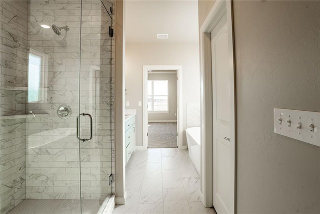 bathroom with vanity and shower with separate bathtub