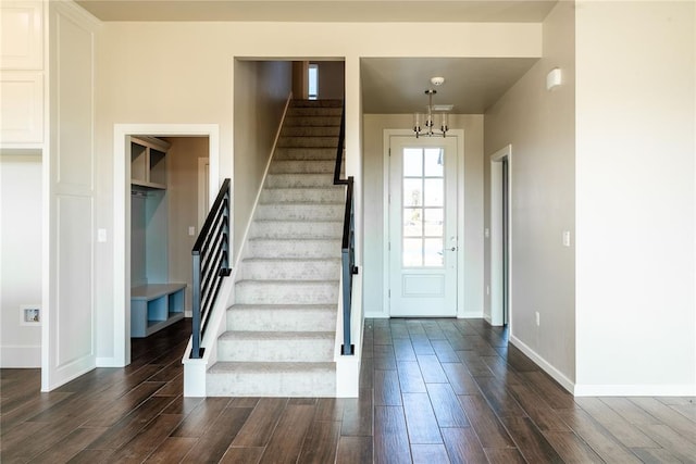 entrance foyer with dark hardwood / wood-style floors and an inviting chandelier