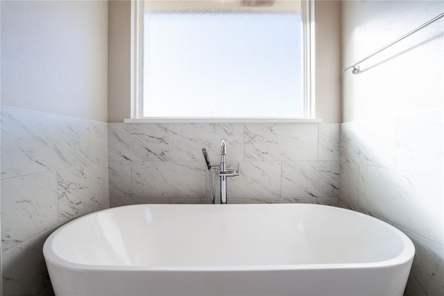 bathroom featuring a tub to relax in and tile walls