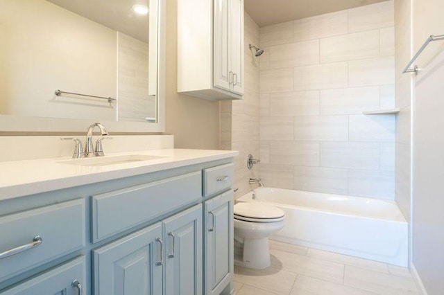 full bathroom featuring tile patterned flooring, vanity, toilet, and tiled shower / bath combo