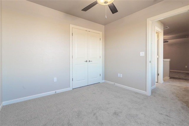 unfurnished bedroom featuring ceiling fan, a closet, and light carpet