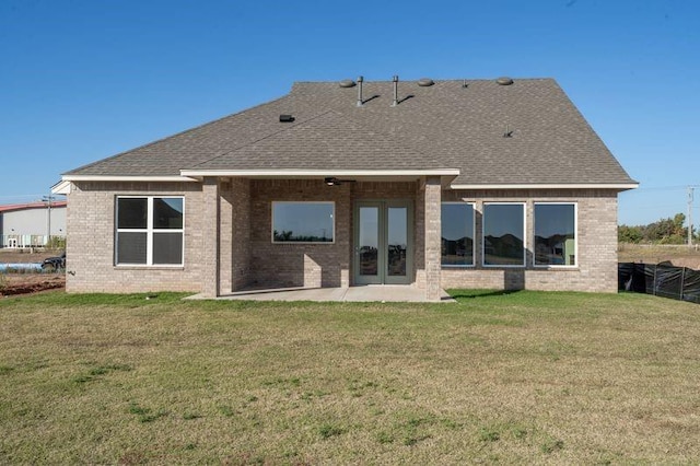 back of property with a lawn and a patio