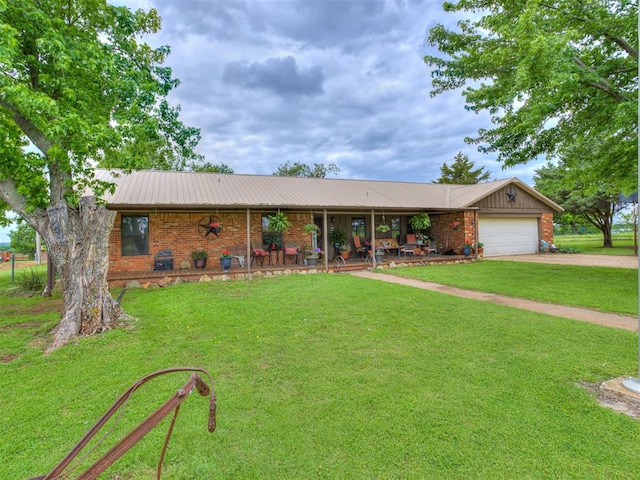 ranch-style home featuring covered porch, a garage, and a front yard