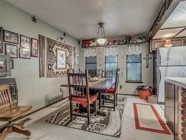 dining space featuring a textured ceiling and light colored carpet