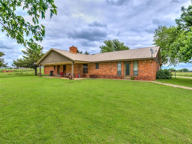 ranch-style home featuring a front lawn and a patio