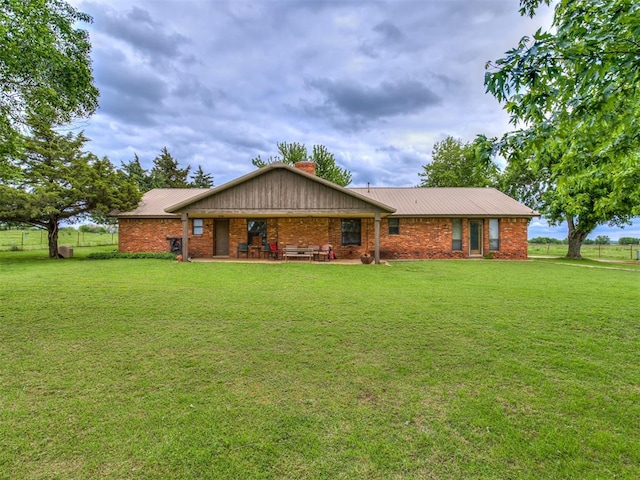 ranch-style home featuring a front lawn and a patio