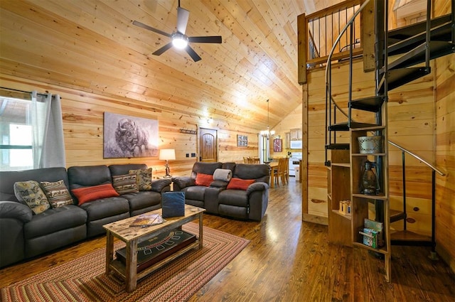 living room with ceiling fan with notable chandelier, dark wood-type flooring, vaulted ceiling, and wooden walls