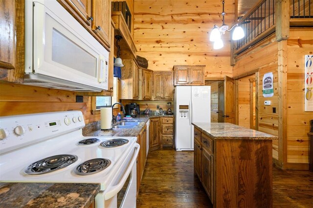 kitchen featuring sink, dark hardwood / wood-style flooring, dark stone countertops, decorative light fixtures, and white appliances