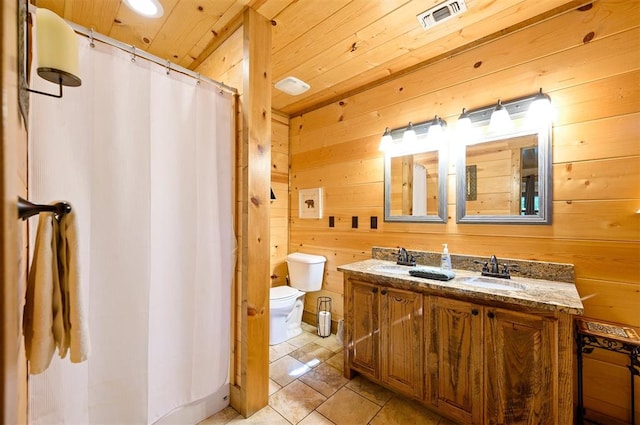 bathroom with vanity, wood walls, wooden ceiling, tile patterned floors, and toilet