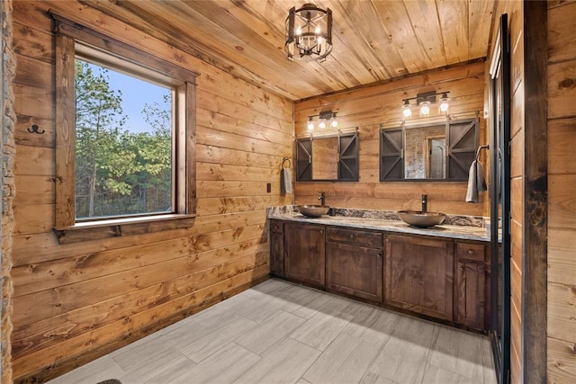 bathroom featuring a chandelier, vanity, wood ceiling, and wood walls